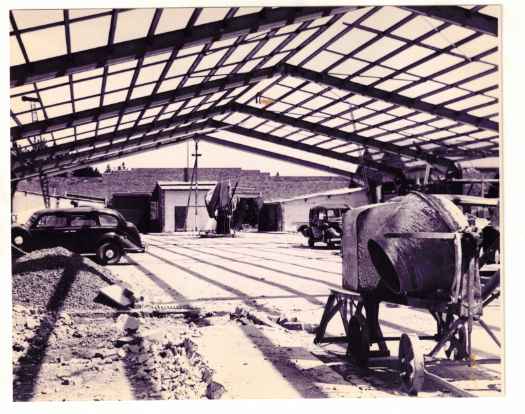 Internal photograph showing concrete mixer. Roof structure appears nearly complete.