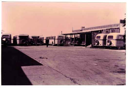 Shows busses parked outside at the original bus depot.
