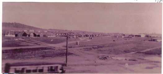 Long view taken from Wentworth Avenue. Kingston shops on right and Printers Quarters at centre. On left are Kennedy Street cottages (see photographs 10484 and 10485) Bus at bottom left.