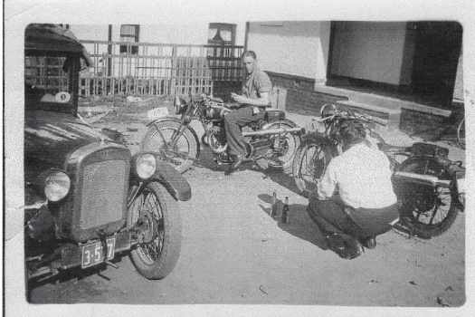 Two men and their motorcycles, and a car.