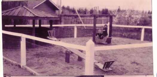 Enclosed playground with two children.