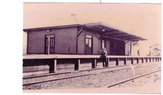 Man standing in front of 1927 station. The first station building is at far right (built 1914).