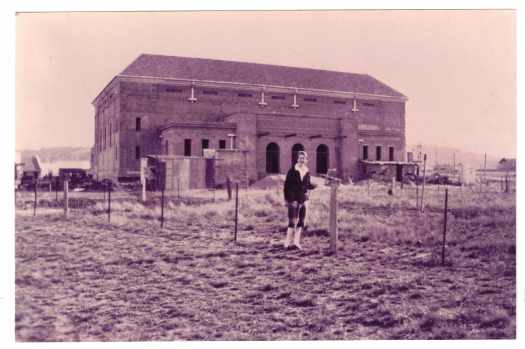 Agnes Benson is standing in a grassy paddock in front of the incomplete Capitol Theatre.