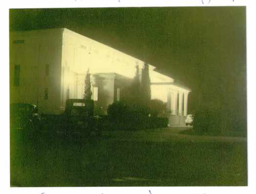 The front of the building is floodlit.